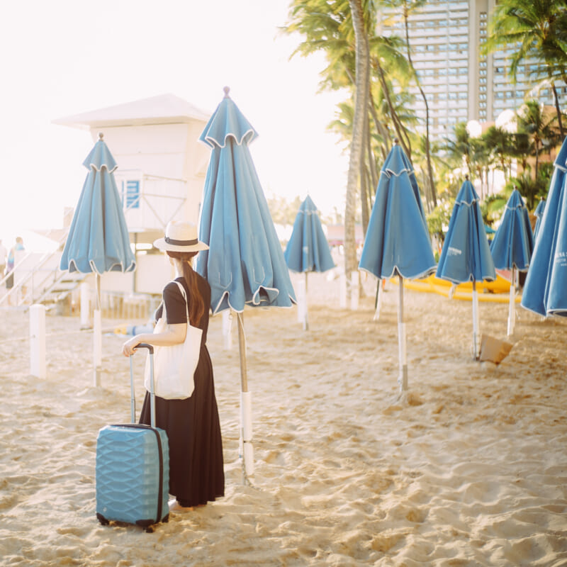 水色のスーツケースを持つ女性