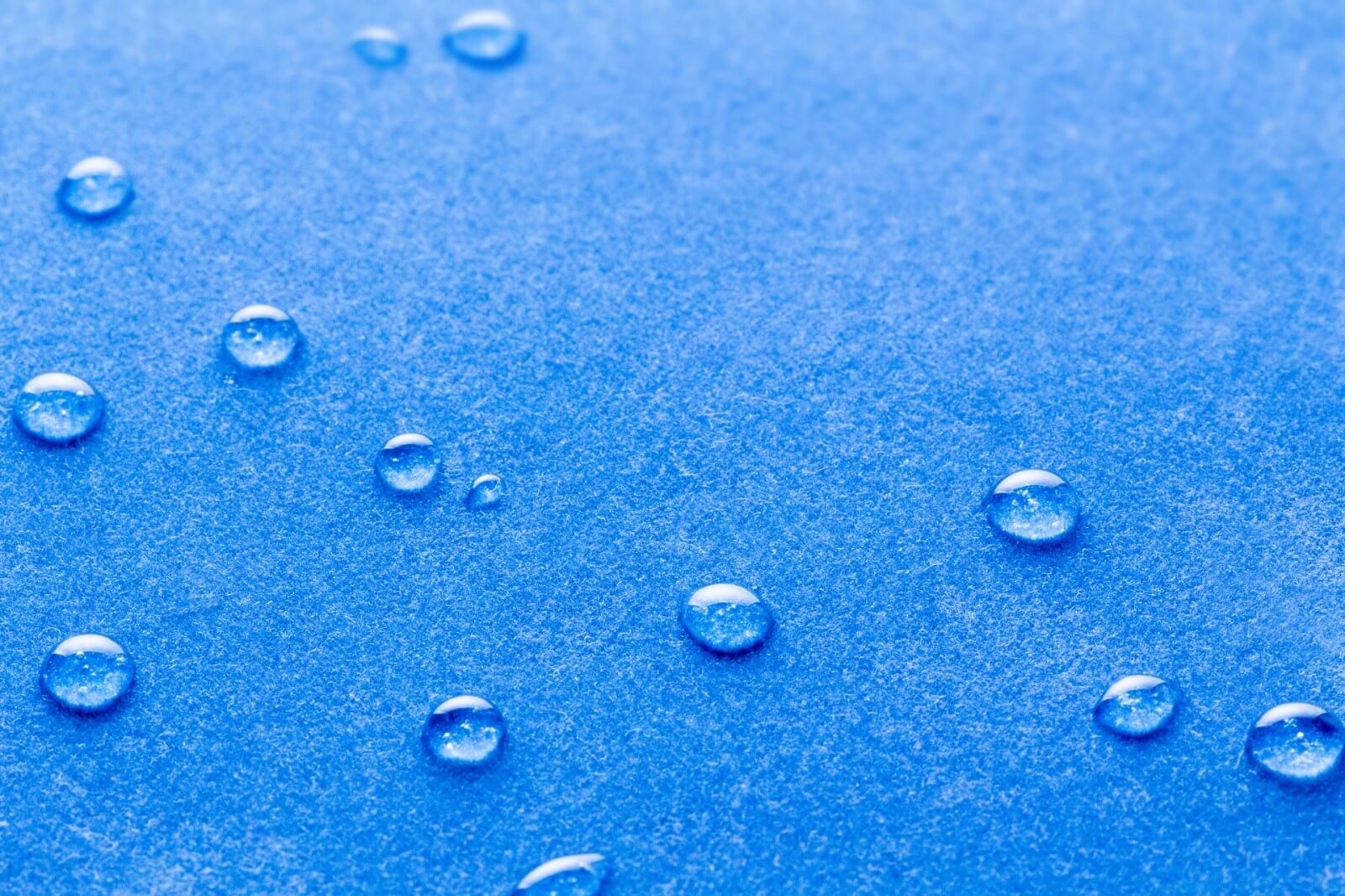 青色のボディにいくつもの水滴がついている様子。撥水加工が施されている