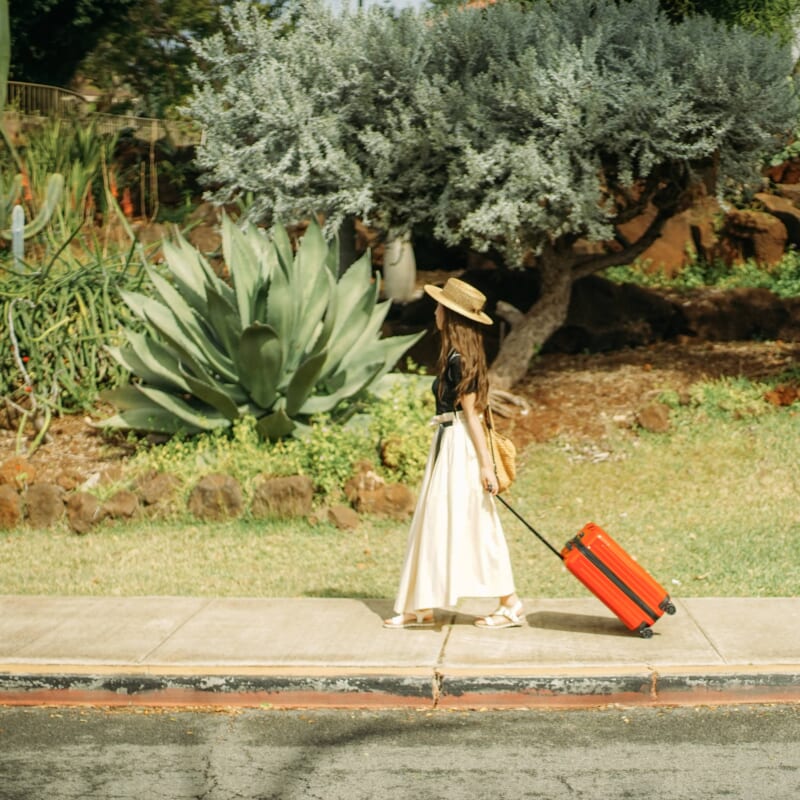 スーツケースを引いて歩く女性