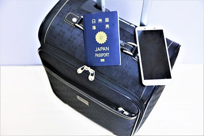 スーツケースの上にパスポートとスマートフォン